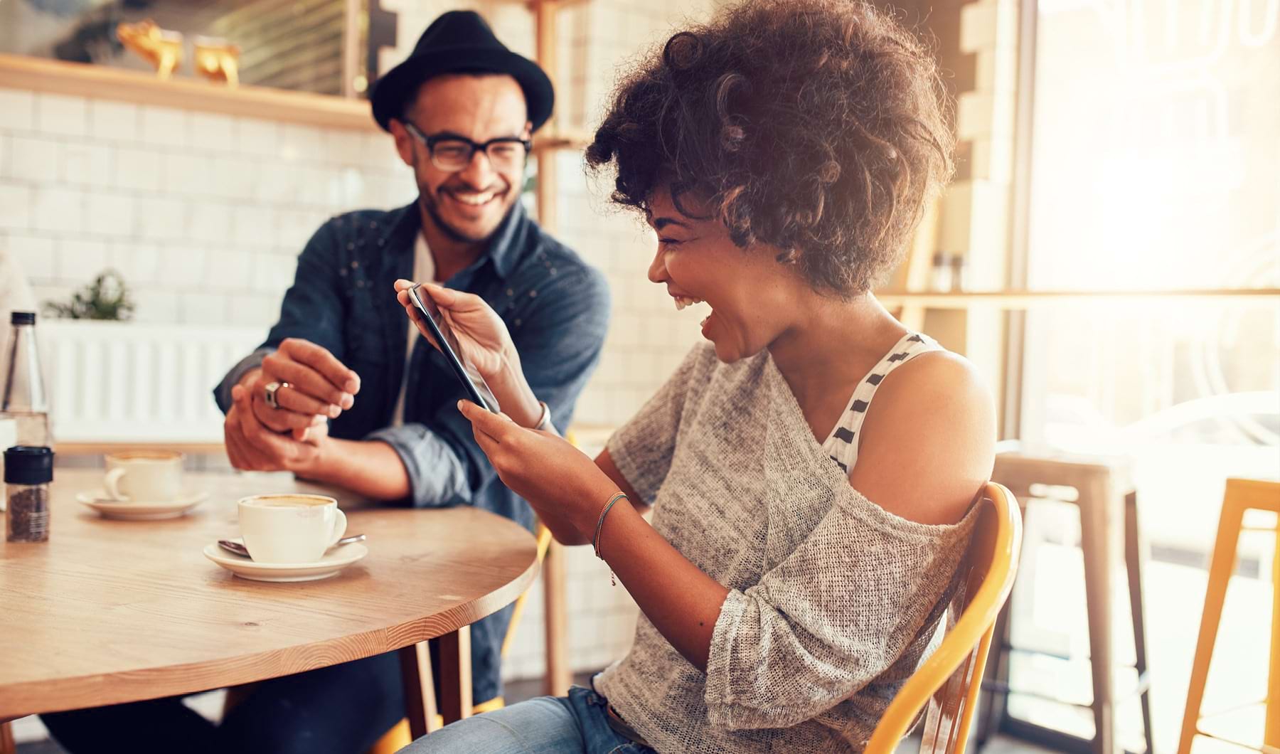 Couple hanging out in a cafe laughing Couple hanging out in a cafe laughing